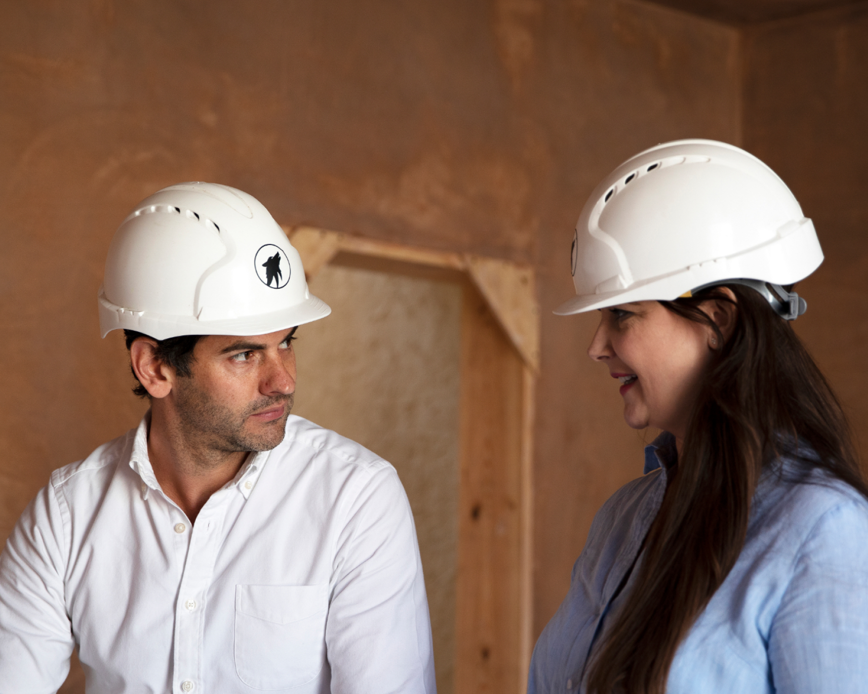 Lawrence Mark and Emily Inman in hard hats talking.